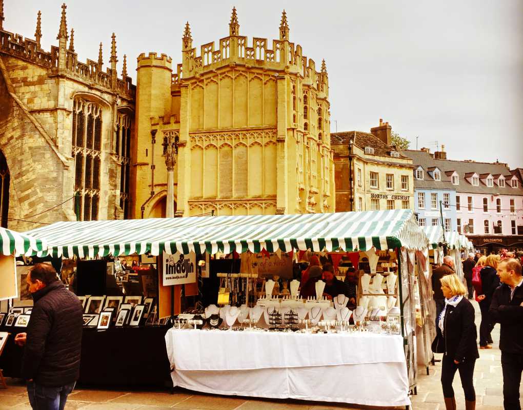 The Charter Market in Cirencester Market against the backdrop of the Parish Church of St John Baptist